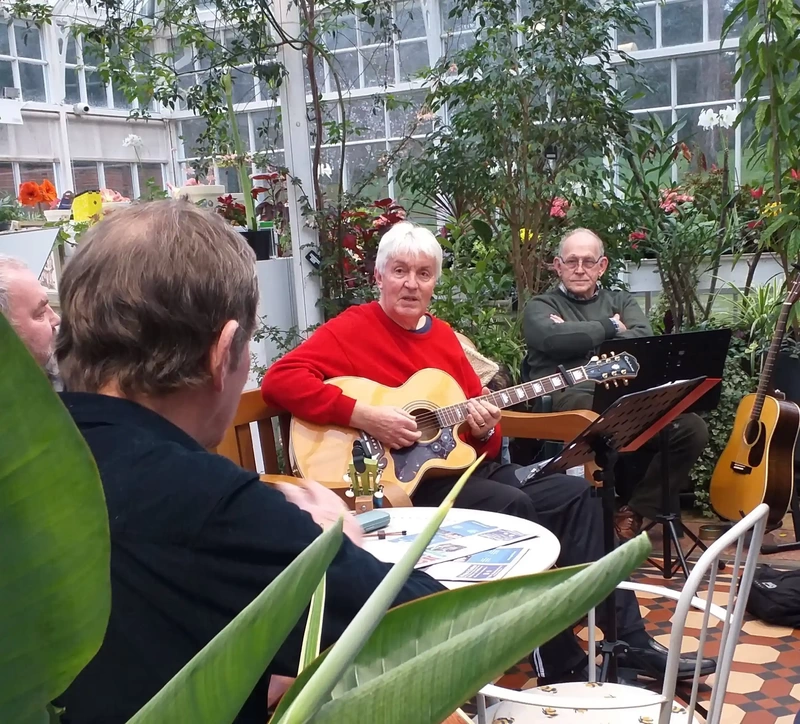 Man playing guitar and singing in Conservatory