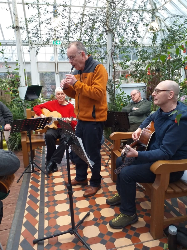 Man playing music on tin whistle in Conservatory